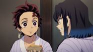 Tanjiro offering food to Inosuke